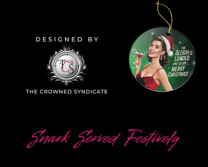 Decorative Christmas ornament with a woman in a Santa hat and red dress, featuring text 'The Sleigh is Loaded and So Am I Merry Christmas!'. Designed by The Crowned Syndicate on a black background.