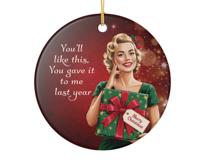 Circular Christmas ornament with a vintage-style illustration of a woman holding a gift, text 'You'll like this, You gave it to me last year', and a red background.