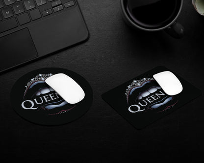 Two mouse pads with 'Queen' logo on a dark surface next to a keyboard and mug.