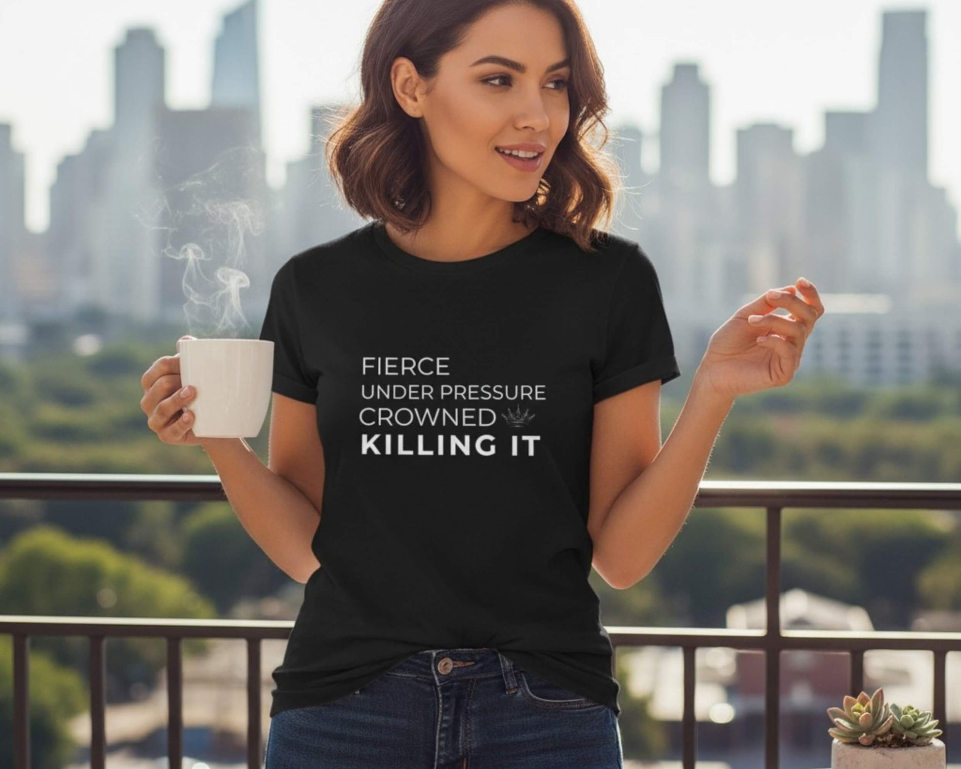 Woman wearing a black t-shirt with text, holding a mug, with a cityscape in the background