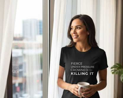 Woman wearing a black t-shirt with motivational text, holding a mug indoors.