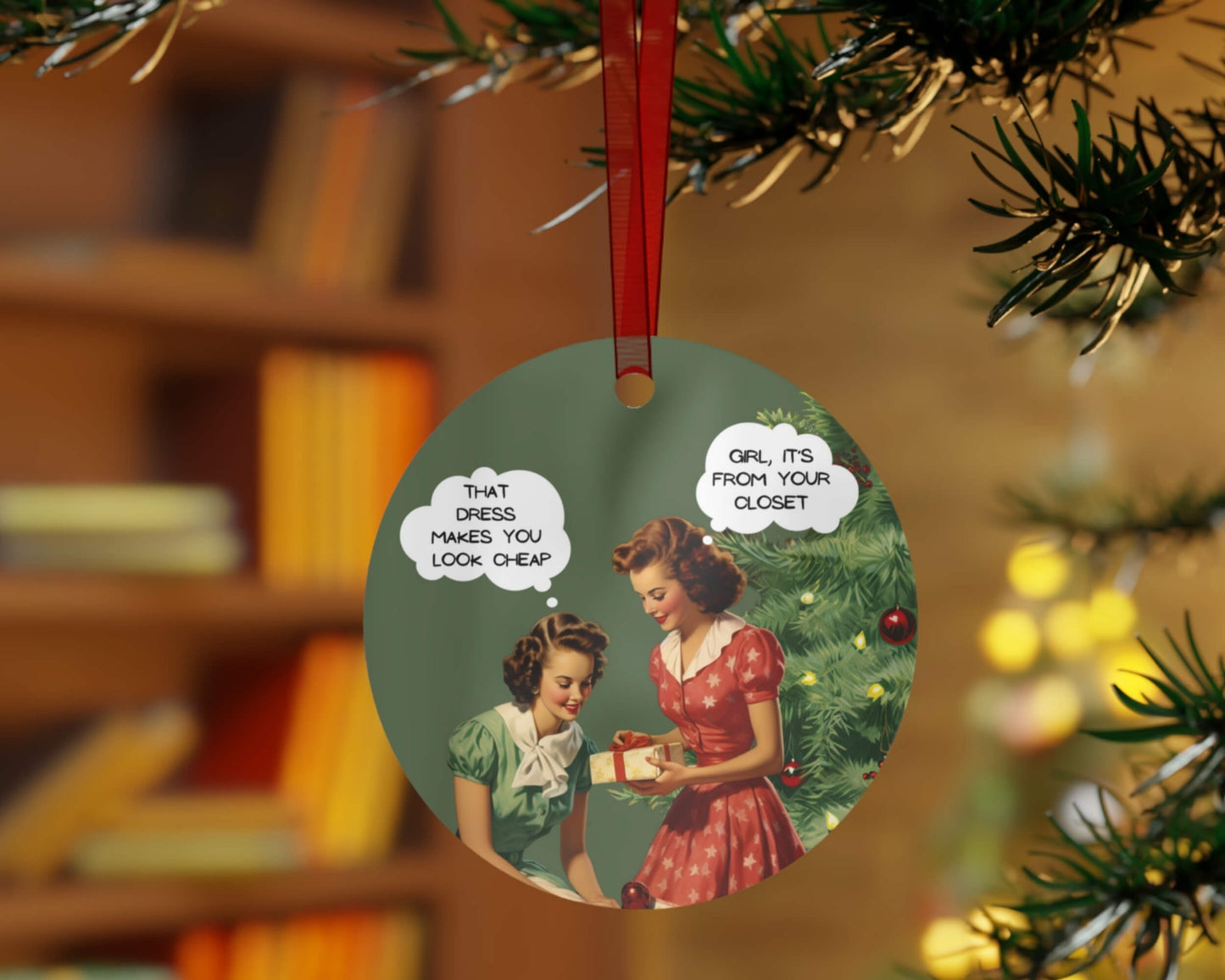 Decorative Christmas ornament with vintage illustration of two women and humorous text, hanging on a tree.