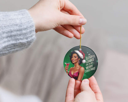 Circular Christmas ornament with a festive design held by a person against a neutral background