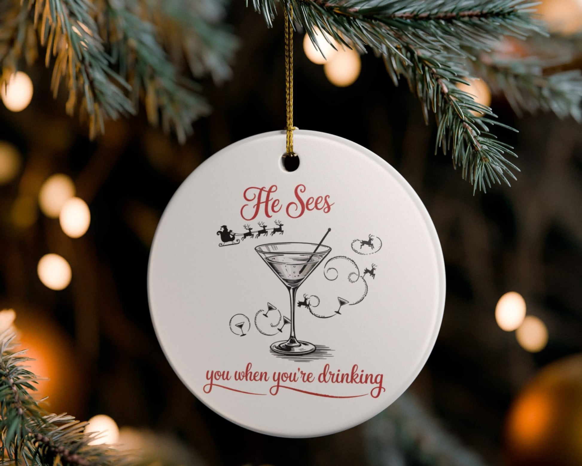 Decorative Christmas ornament with a cocktail graphic and text, hanging on a tree.