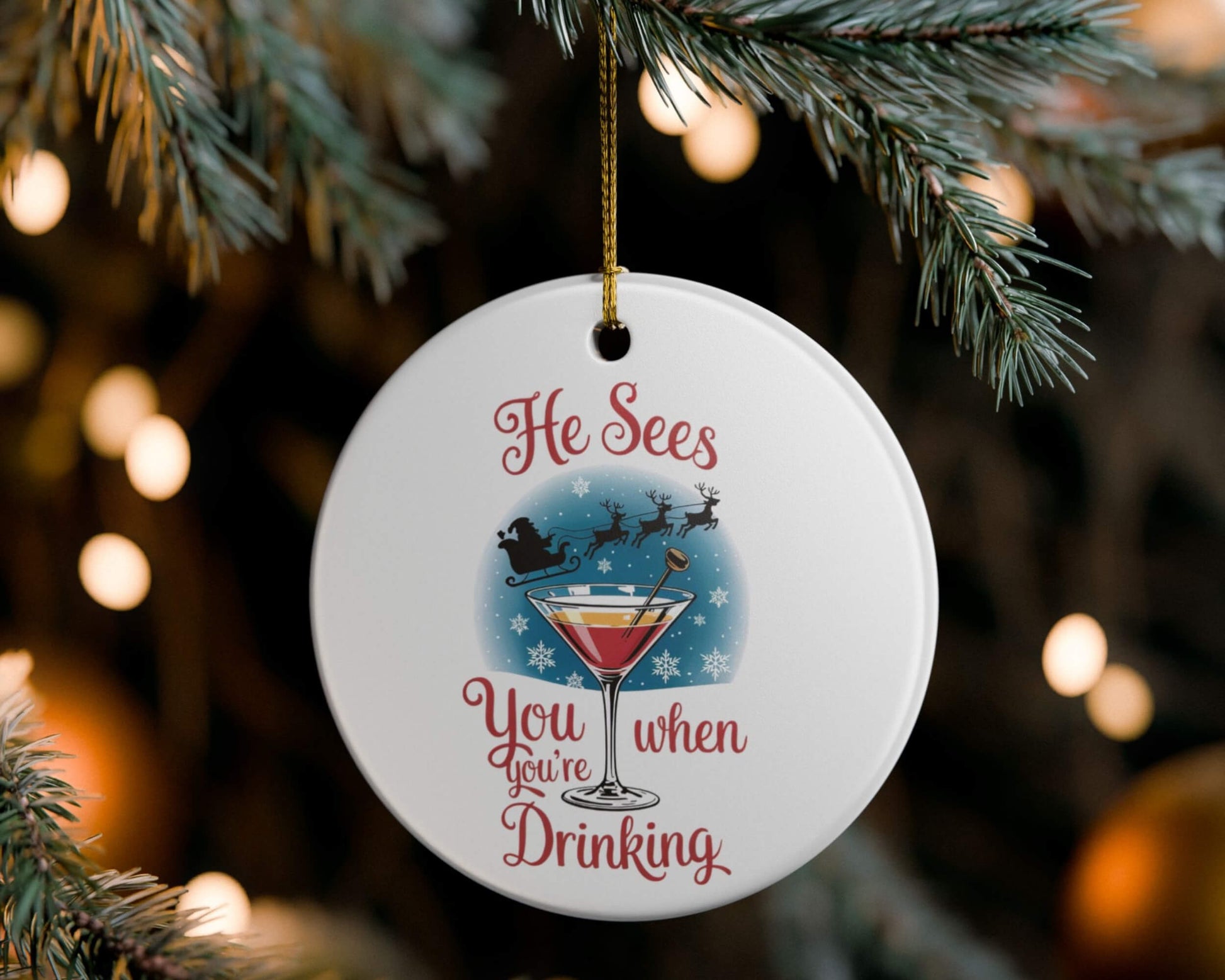 Decorative Christmas ornament with a cocktail graphic and text, hanging on a tree.