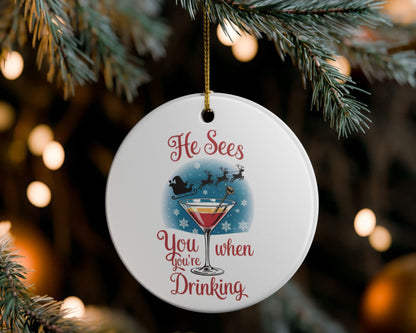 Decorative Christmas ornament with a cocktail graphic and text, hanging on a tree.